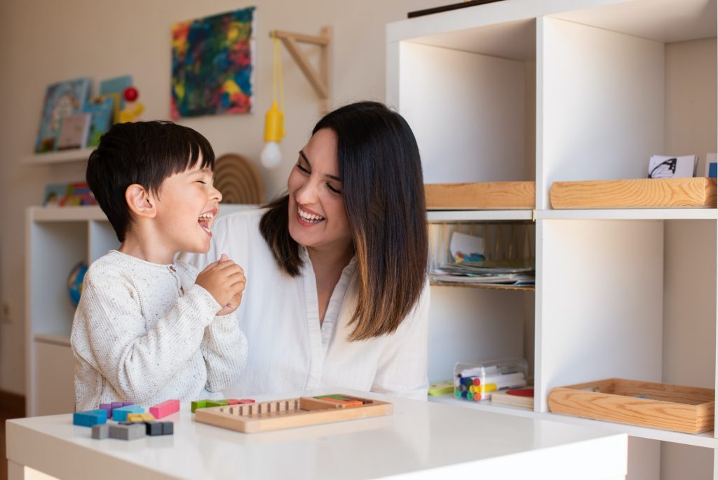 kid-playing-with-a-tetris-wood-puzzle-and-mother-or-teacher-help-.jpg